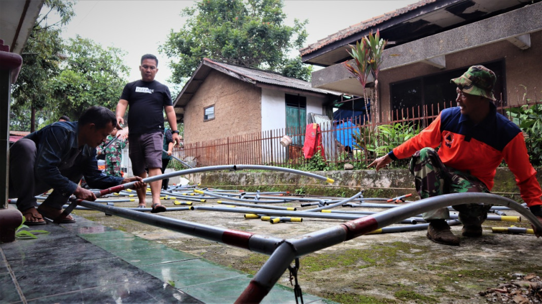 BNPB bersama tim gabungan mendirikan tenda di Desa Cikaroya, Warung Kondang, Cianjur, Jawa Barat, Sabtu (24/12). Beberapa pembaharuan tenda mandiri dilakukan sambil menunggu bantuan dana stimulan bisa digunakan untuk memperbaiki rumah yang rusak.