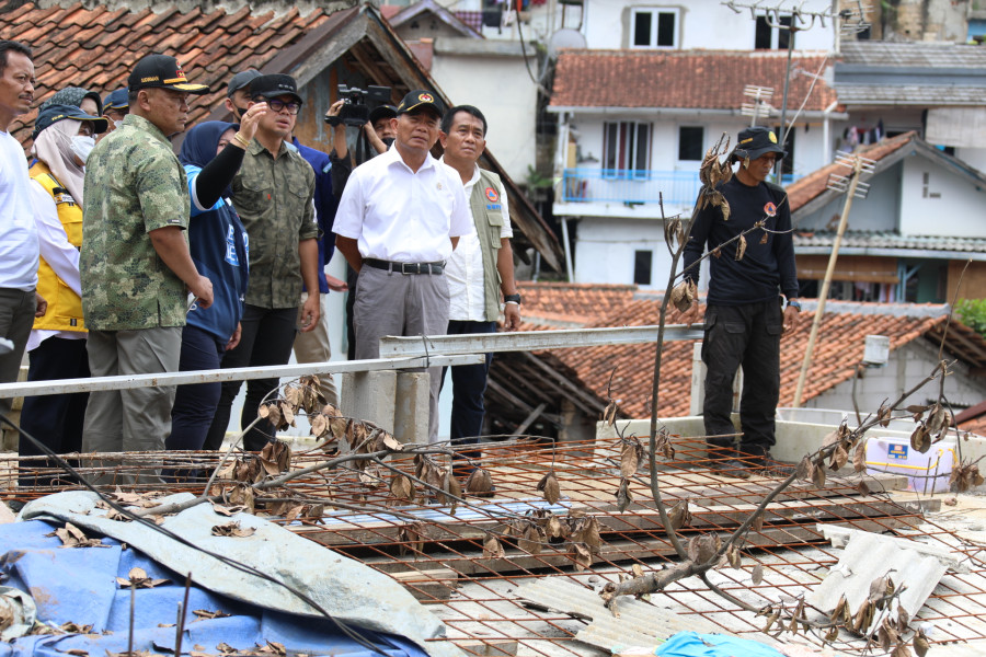 Deputi Bidang Penanganan Darurat BNPB Mayjen Fajar Setyawan (kemeja putih dengan rompi) bersama Menko PMK Muhadjir Effendy (kemeja putih) mendapat penjelasan terkait kondisi pasca tanah longsor di Kecamatan Bogor Tengah, Kota Bogor, Jawa Barat, Sabtu (22/10).