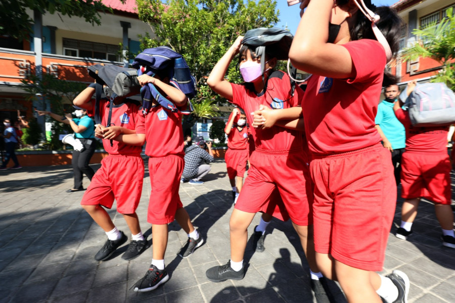 Siswa SD No.2 Tanjung Benoa melakukan simulasi latihan evakuasi mandiri saat terjadi gempabumi, Selasa (24/5).